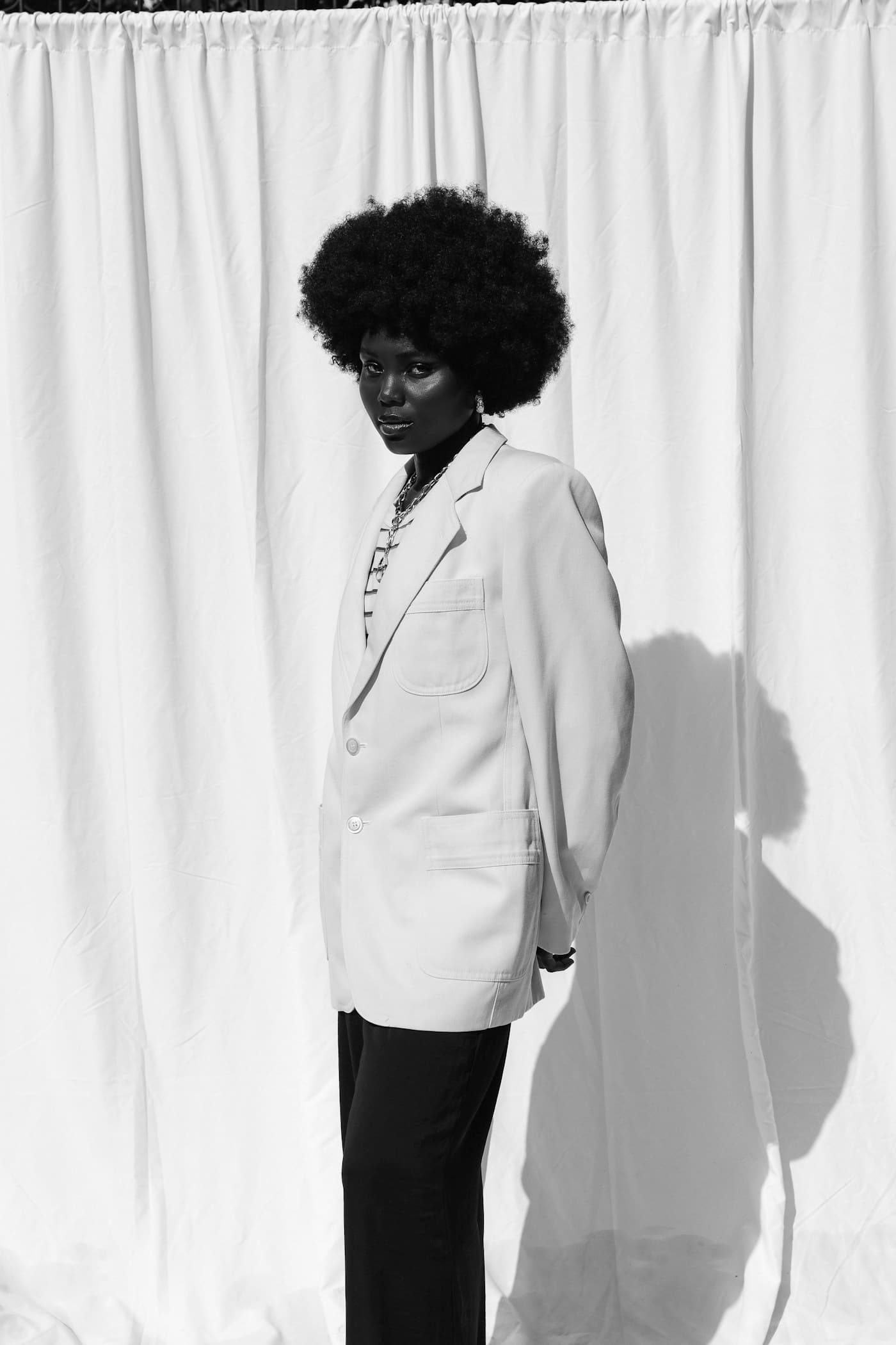 Black-and-white fashion portrait of a woman in a white blazer